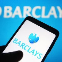 Barclays logo as seen on a smartphone in front of its logo on computer screen