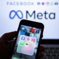 The app icons of Facebook, Messenger, Instagram, WhatsApp and Oculus VR display on a smartphone screen in front of the Meta logo