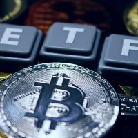 Keyboard letters spell out ETF on a pile of bitcoin tokens