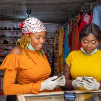 Two African women paying via mobile transfer in a clothes shop and paying with cryptocurrency / Photo: Shutterstock