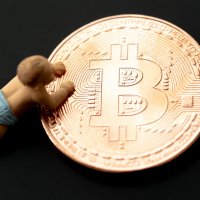 Concept of a baby crawling onto a large bitcoin