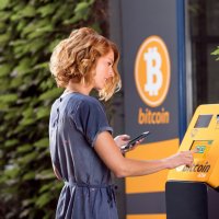 Woman in front of bitcoin ATM
