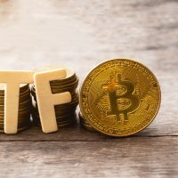 A representative golden bitcoin token stands next to more coins and the letters ETF 