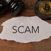 Judge gavel, golden bitcoin and torn paper written with SCAM