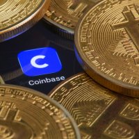 The Coinbase logo peeks through a gap in a pile of Bitcoins