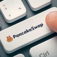 PancakeSwap written on a keyboard button, which is being pressed by a user