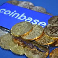 Coinbase logo among bitcoins – Photo: Shutterstock