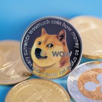 A pile of crypto tokens on a blue background with Dogecoin at the front