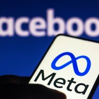 The Meta logo displayed on a smartphone and in the background the Facebook logo