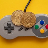Two bitcoins placed on a Super Nintendo controller