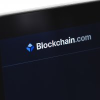 Blockchain.com name and logo is displayed in a close up of a smartphone screen