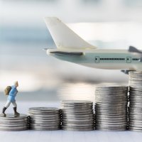 Man walking on coins, with plane in background