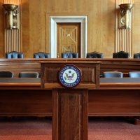 Inside the United States senate while empty, looking at a panel of desks and chairs with 