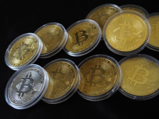 Pile of silver and gold coins designed to represent cryptocurrencies including Bitcoin