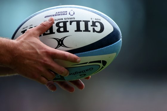 Close up of a rugby player’s hands holding a rugby ball