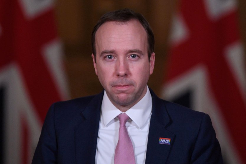 Portrait of MP Matt Hancock in front of two Union Flags of the UK