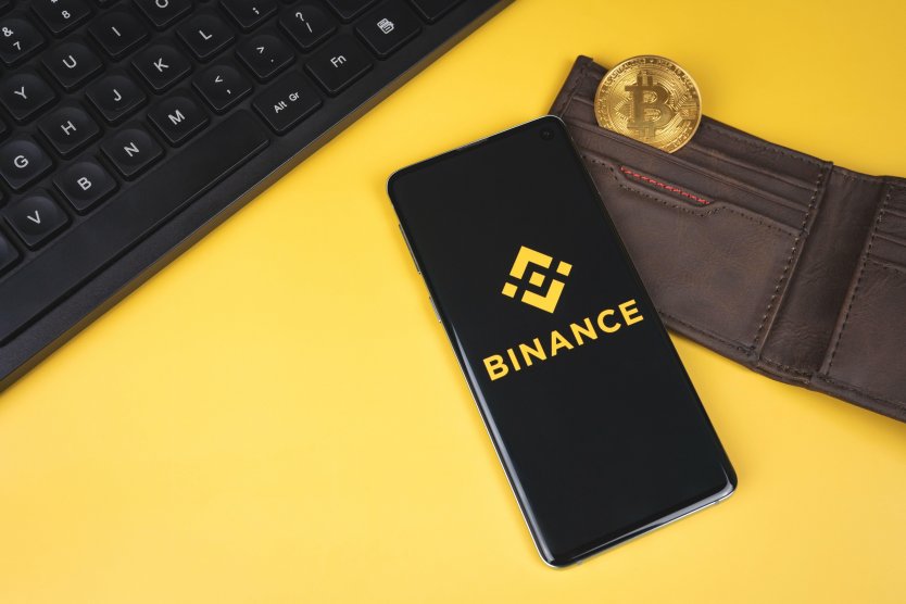 Binance mobile app logo on a smartphone, wallet with bitcoin 