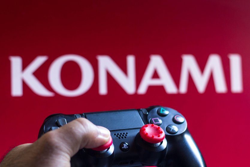 A PlayStation controller and the Konami Holdings Corporation logo seen in the background 