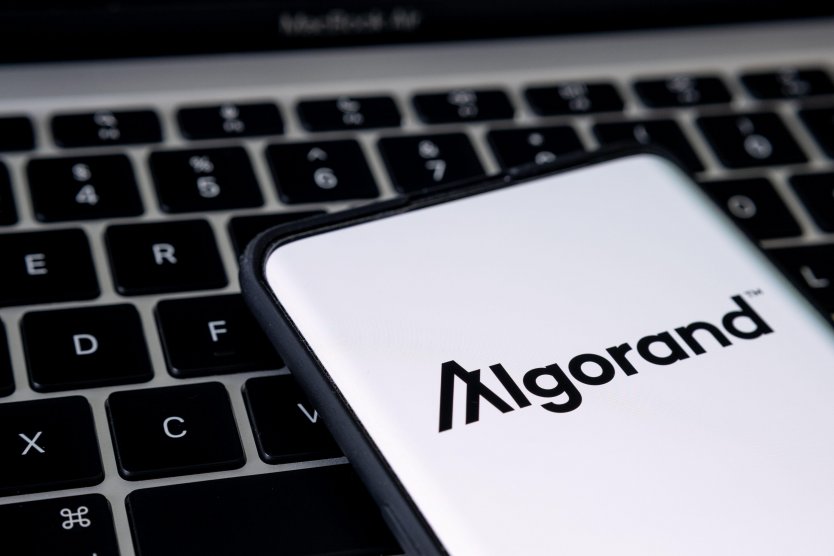 Algorand cryptocurrency platform logo seen on smartphone placed on keyboard of laptop
