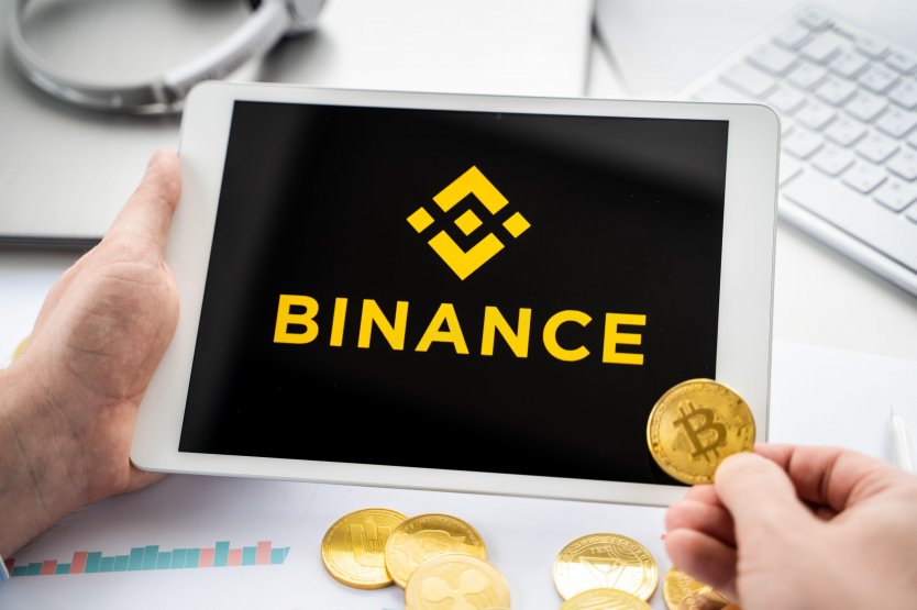 Businessman with tablet and logo of Binance