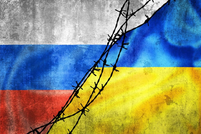 Representation of Russian Federation and Ukraine flags divided by barbed wire