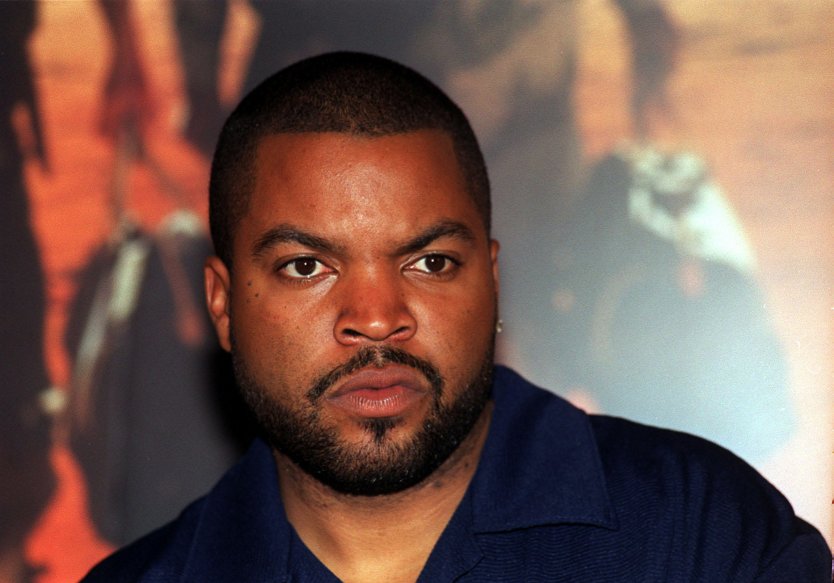 Ice Cube poses for the media in front of a poster for his film, 'Three Kings', in London