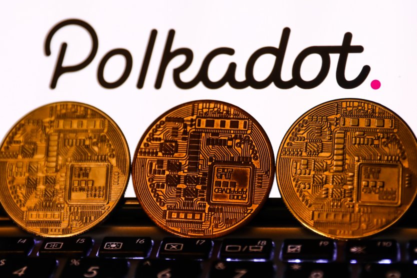 Polkadot cryptocurrency logo displayed on a phone screen and representation of cryptocurrency