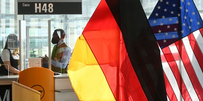 A desk of German airline Lufthansa is decorated with flags of Germany and the US
