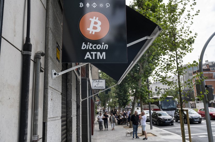  A sign outside a store in Madrid, Spain, advertises a Bitcoin ATM
