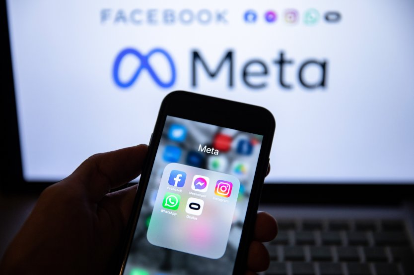 The app icons of Facebook, Messenger, Instagram, WhatsApp and Oculus VR display on a smartphone screen in front of the Meta logo