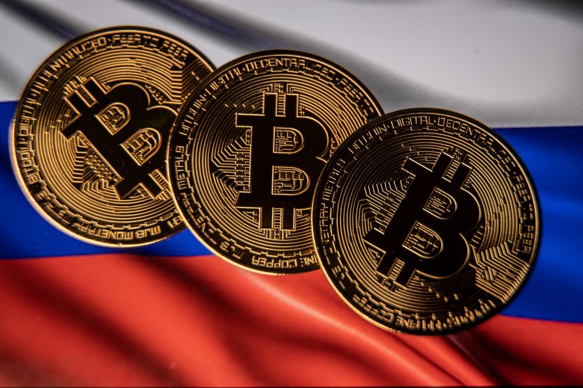 In this photo illustration a novelty Bitcoin token is photographed with a Russian flag, on 13 March, 2022 in Bristol, England