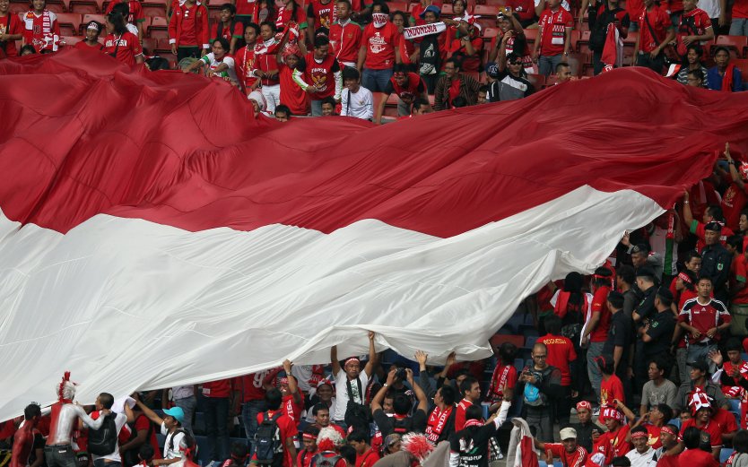 Indonesian football fans wave a giant flag