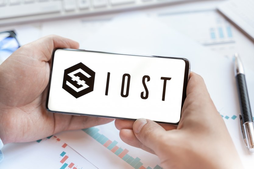 IOST logo displayed on a smartphone screen