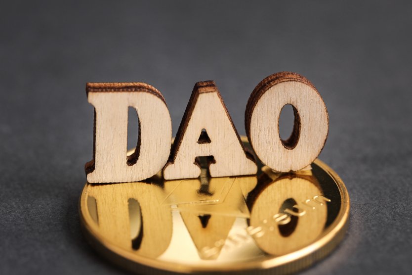 The text DAO sitting on a gold Ethereum coin