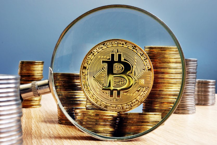Bitcoin, coins and magnifying glass