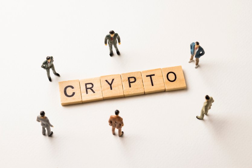 Crypto written on wooden blocks and surrounded by people