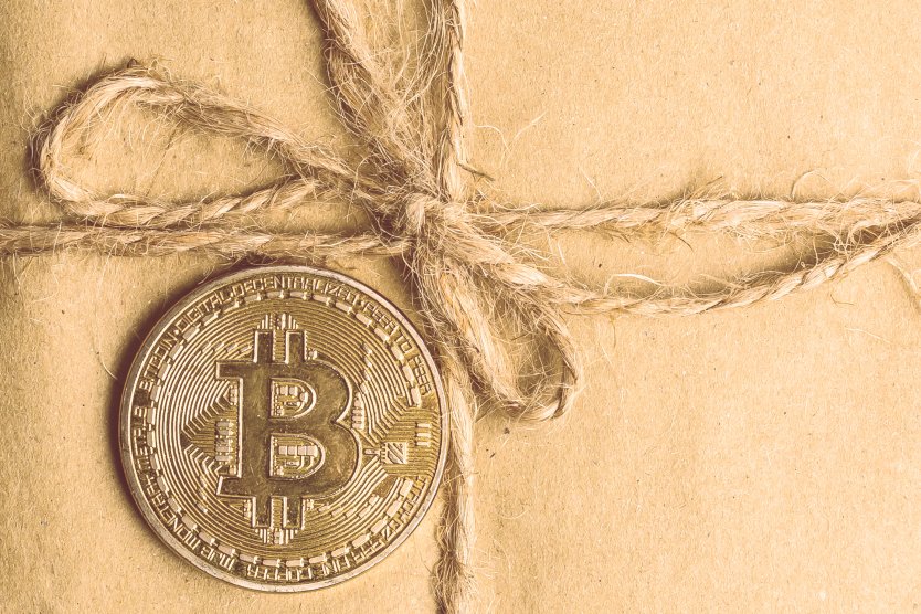 Bitcoin on top of a paper gift box 