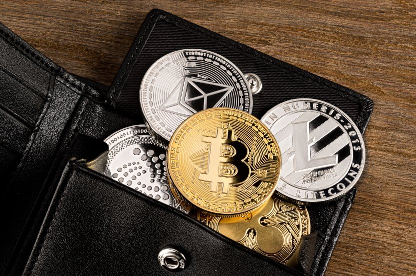 Physical wallet with several crypto assets falling out