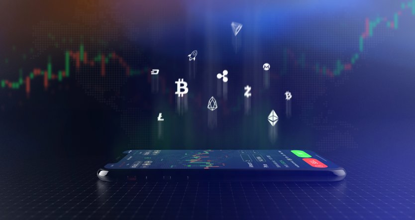 Representation of cryptocurrency symbols hovering above a smartphone displaying a trading chart