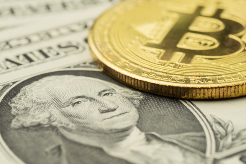 Close-up of George Washington’s image on US dollar banknote with golden bitcoin cryptocurrency coin on top of it