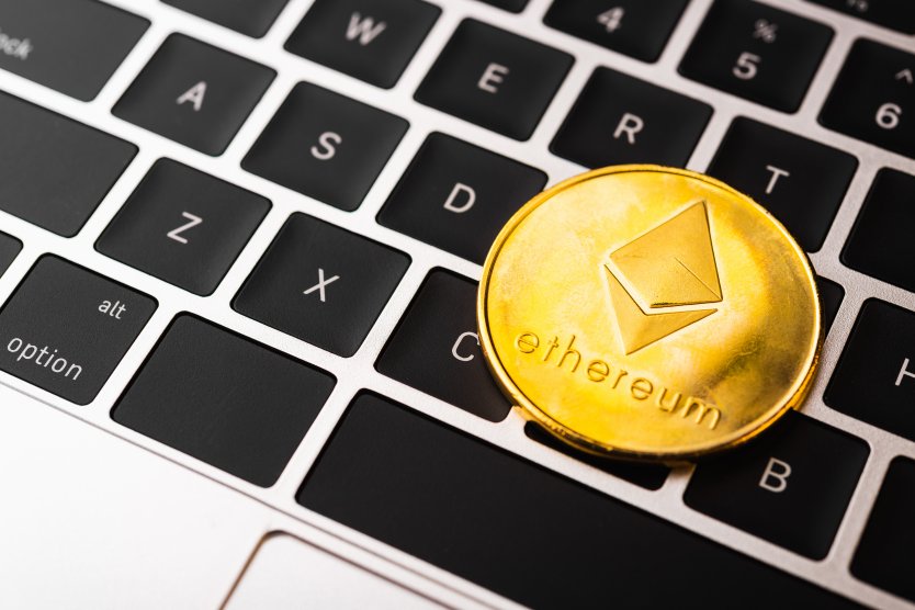 Representation of a golden ETH token resting on a computer keyboard