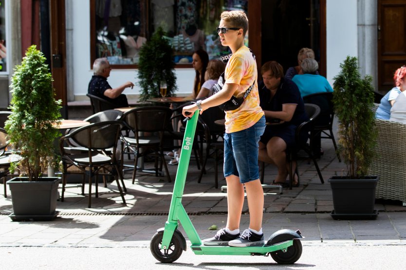 A boy on a green Bolt e-scooter