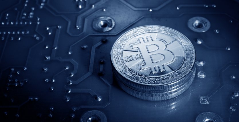 A BTC token sits on a blue blockchain background