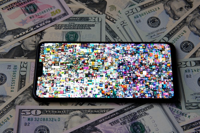 Image of Beeple's digital artwork NFT on a smartphone on top of several US greenbacks