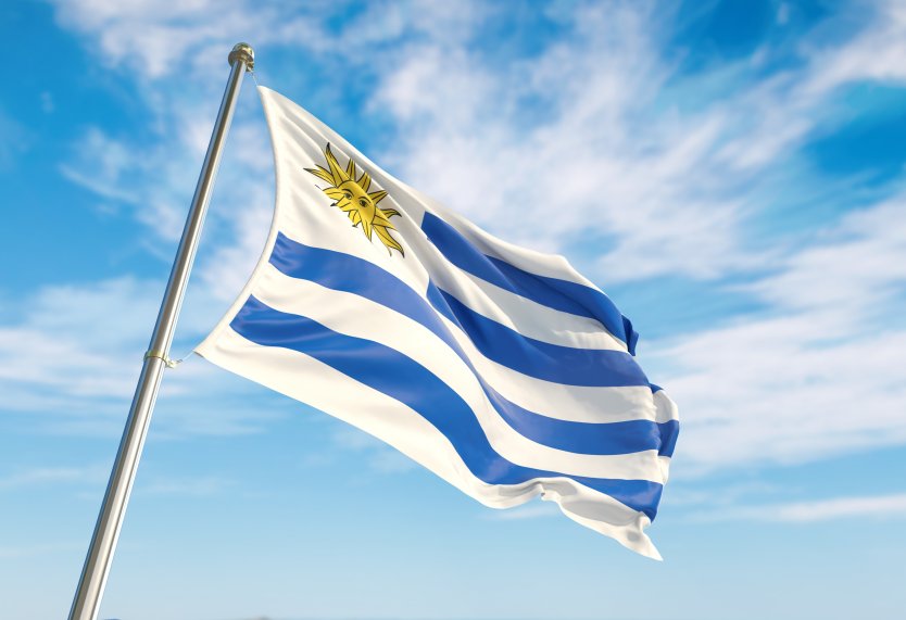 Uruguay flag set against a cloud-filled blue sky