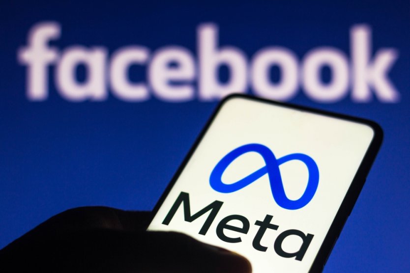 The Meta logo displayed on a smartphone and in the background the Facebook logo