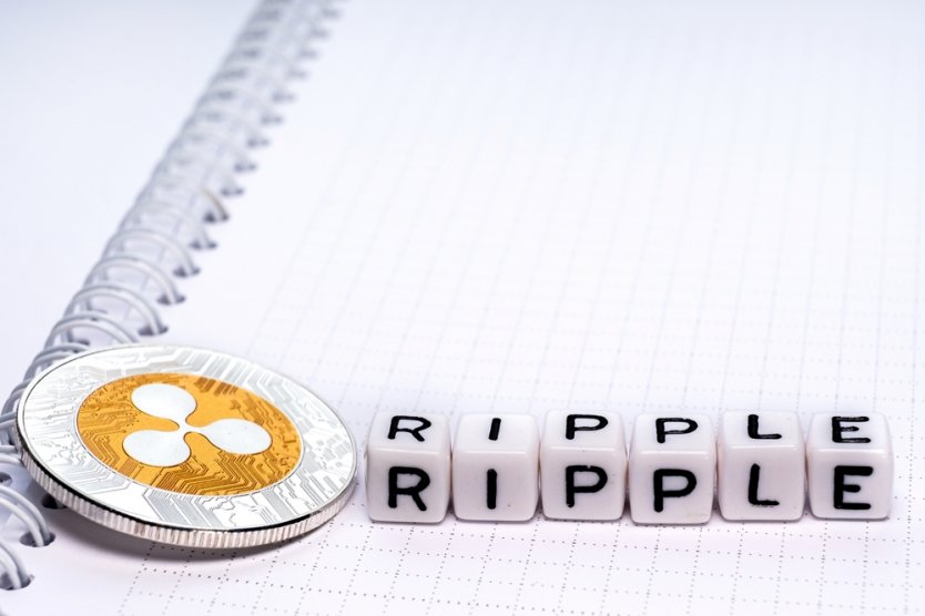 Representation of an XRP coin next to six small letter-embossed cubes that spell out the word Ripple 