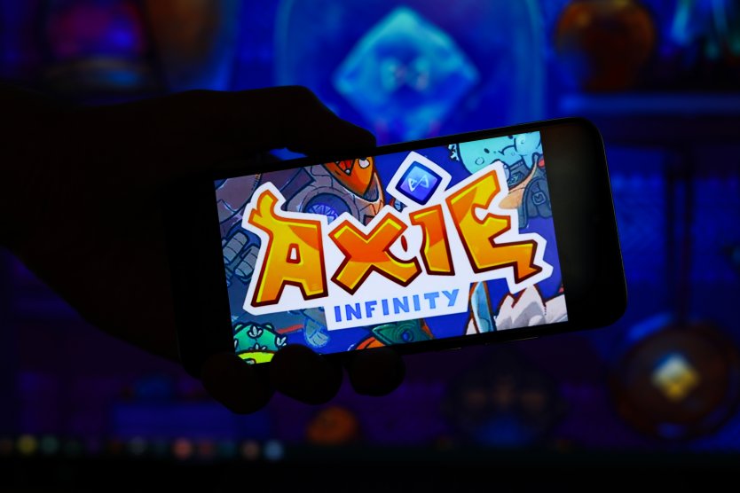 Axie Infinity's cartoon logo shown on a smartphone screen in the dark