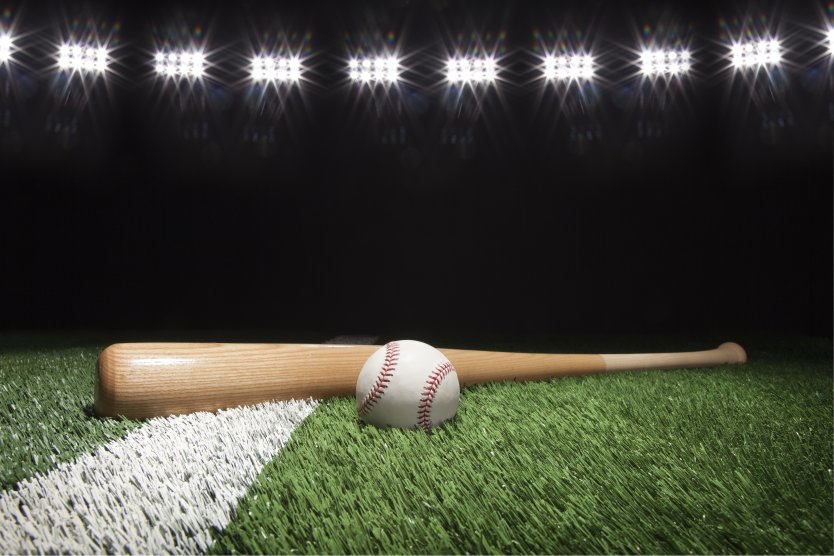 A baseball bat and ball lie on a pitch set against a darkened arena