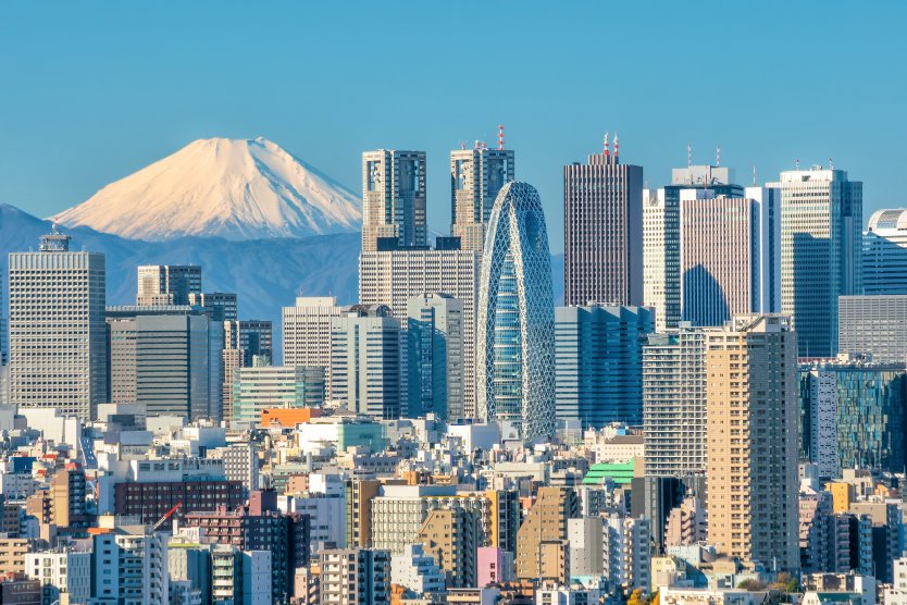 The skyline of Tokyo with skyscrapers in the foreground and Mount Fuji in the distance